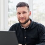 Happy man working on laptop in office