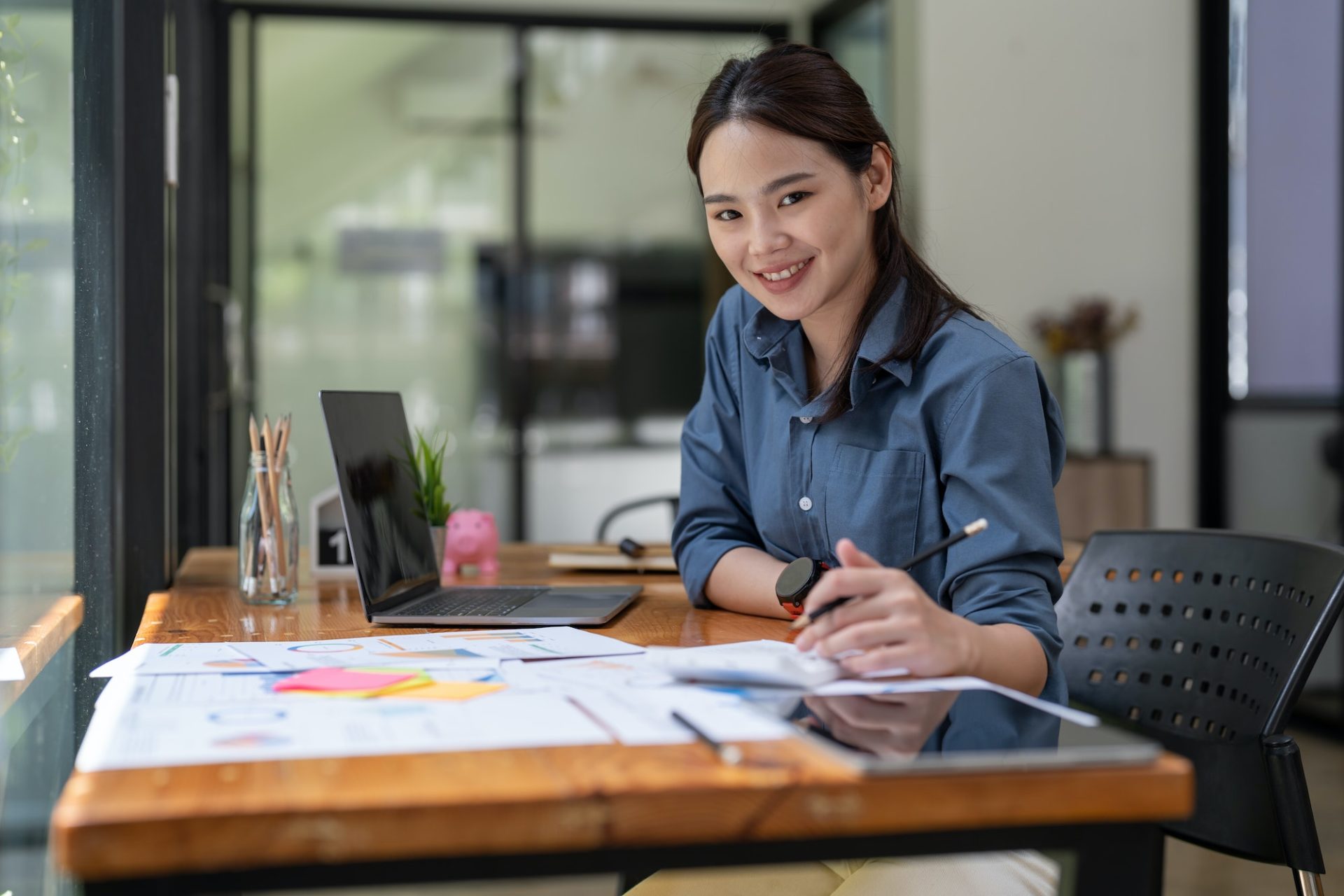 Portrait asian accountant or auditor working with calculator and laptop computer.