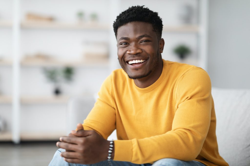 Portrait of successful black guy posing at home